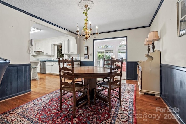 dining space with ornamental molding, hardwood / wood-style floors, and a textured ceiling