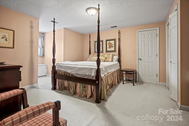 bedroom with light carpet and a textured ceiling