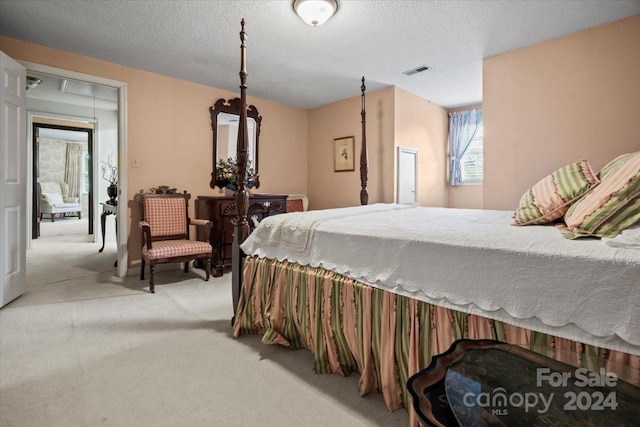 bedroom with light carpet and a textured ceiling