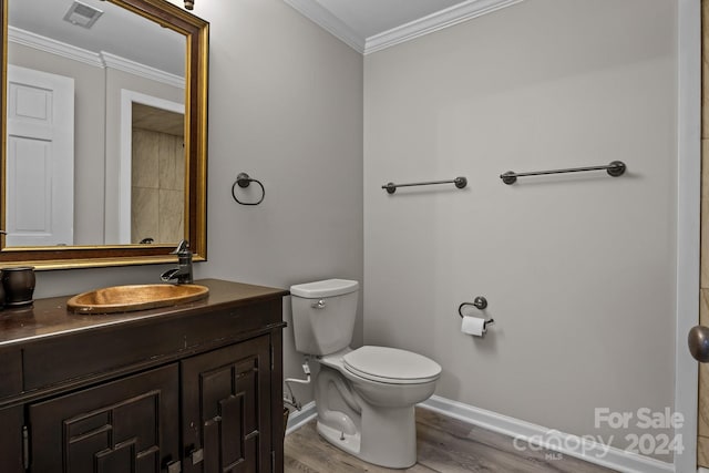 bathroom featuring toilet, vanity, wood-type flooring, and ornamental molding