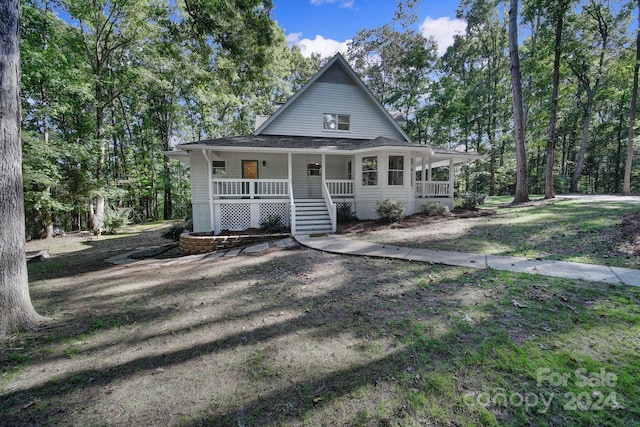 farmhouse-style home with covered porch and a front lawn