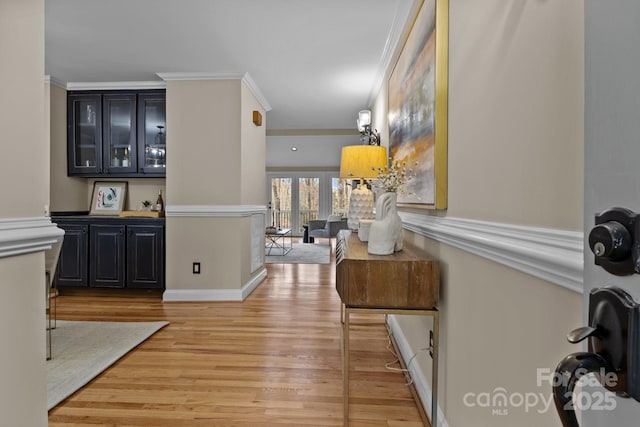 interior space with ornamental molding and light hardwood / wood-style flooring