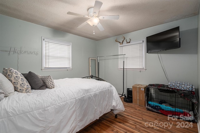 bedroom featuring ceiling fan, a textured ceiling, and hardwood / wood-style floors