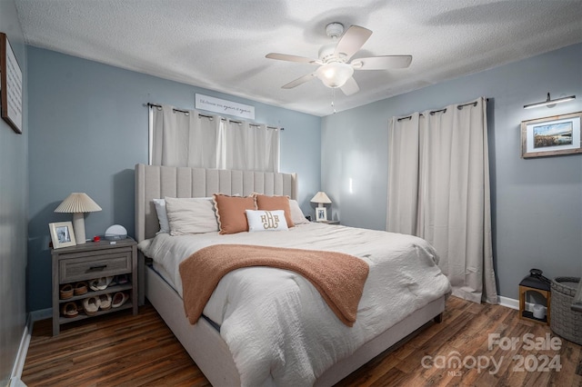 bedroom featuring ceiling fan, dark hardwood / wood-style floors, and a textured ceiling