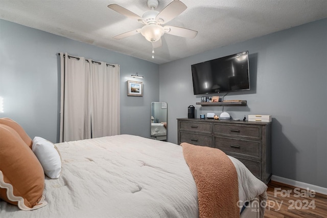 bedroom with hardwood / wood-style flooring, a textured ceiling, and ceiling fan