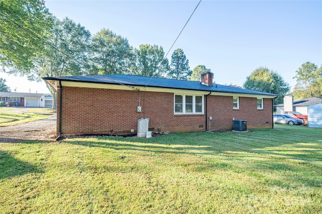 back of house featuring a yard and central AC