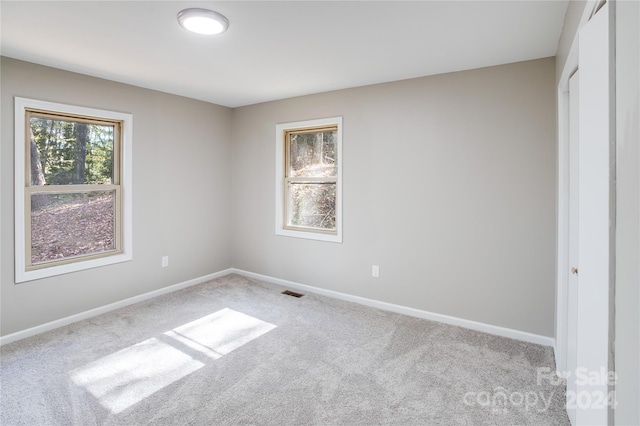 unfurnished room featuring light carpet