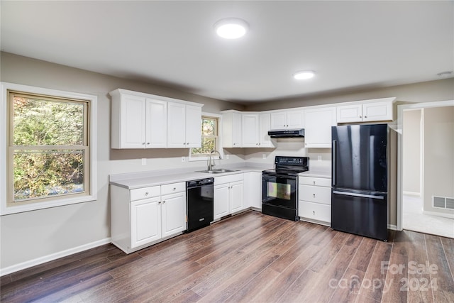 kitchen with a wealth of natural light, white cabinetry, sink, and black appliances