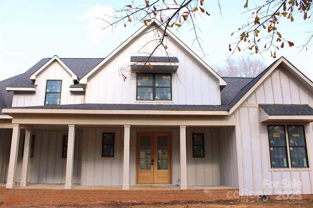 modern farmhouse with covered porch, board and batten siding, french doors, and roof with shingles