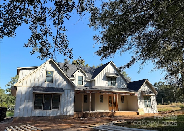 modern farmhouse with covered porch, board and batten siding, and roof with shingles