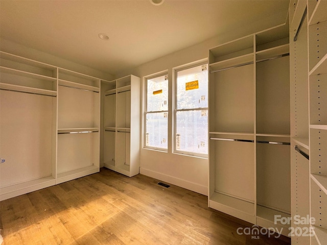 walk in closet with visible vents and wood finished floors