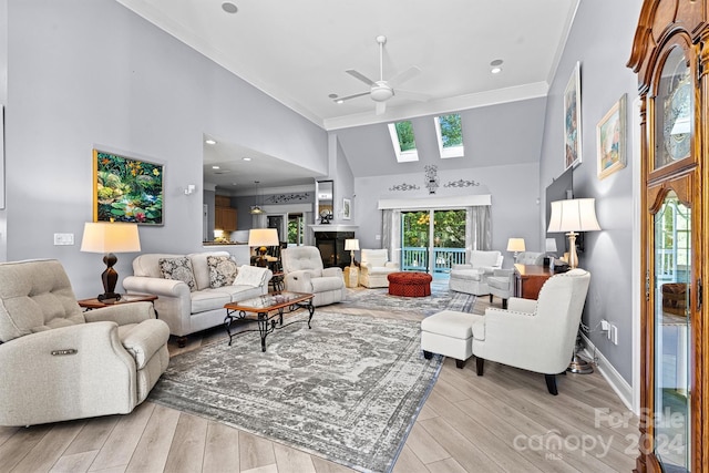 living room featuring crown molding, a skylight, light wood-type flooring, and ceiling fan