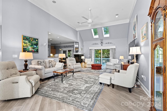 living area featuring a skylight, ceiling fan, a towering ceiling, and ornamental molding