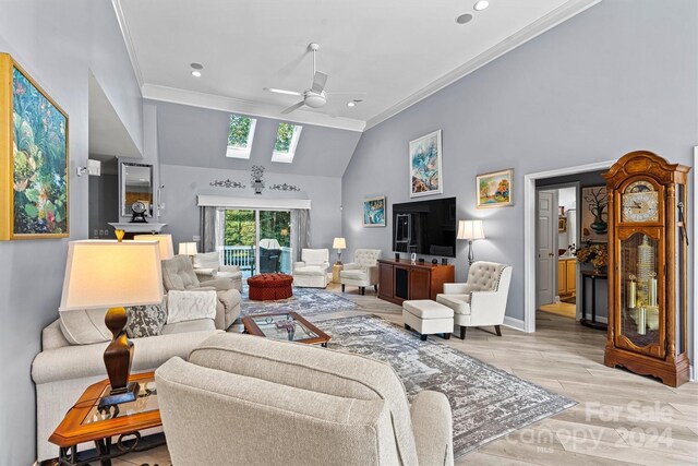 living room with light wood-type flooring, a skylight, ceiling fan, crown molding, and high vaulted ceiling