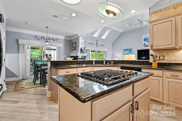 kitchen with pendant lighting, light brown cabinetry, a kitchen island, and light wood-type flooring