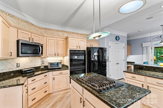 kitchen featuring black appliances, crown molding, hanging light fixtures, and light hardwood / wood-style flooring