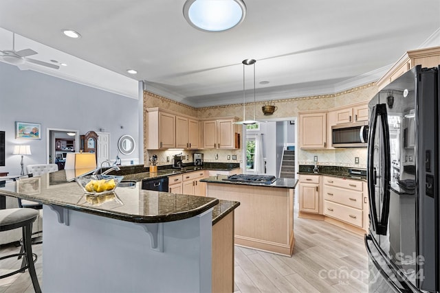 kitchen with hanging light fixtures, kitchen peninsula, crown molding, and black appliances