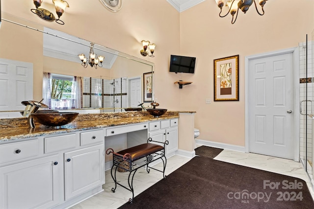 bathroom featuring vanity, crown molding, an inviting chandelier, a shower with shower door, and toilet