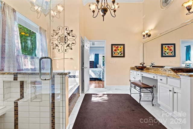 ensuite bathroom with ensuite bathroom, vanity, a chandelier, marble finish floor, and a towering ceiling