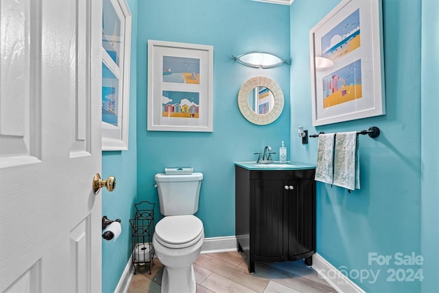 bathroom featuring vanity, toilet, and hardwood / wood-style flooring