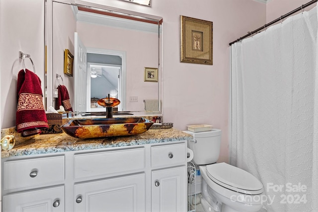 bathroom with ornamental molding, vanity, and toilet