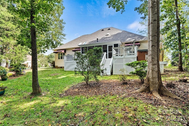 back of property with a wooden deck and a yard