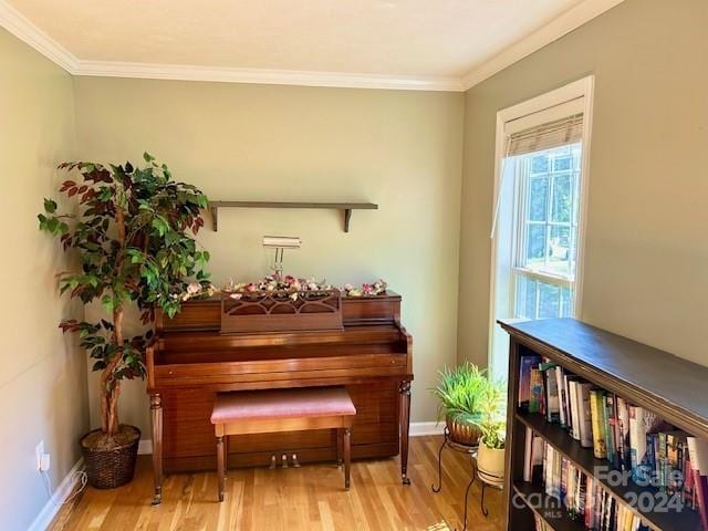 sitting room featuring baseboards, ornamental molding, and wood finished floors