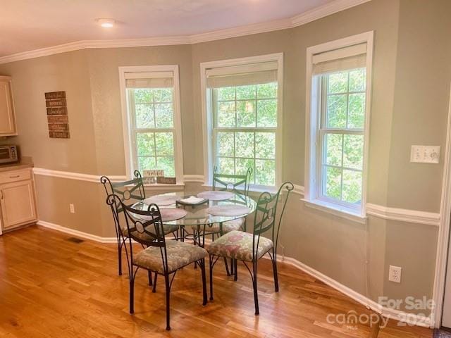 dining space with baseboards, a wealth of natural light, and light wood-type flooring