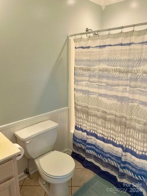 full bathroom featuring tile patterned floors, shower / bath combo with shower curtain, vanity, and toilet