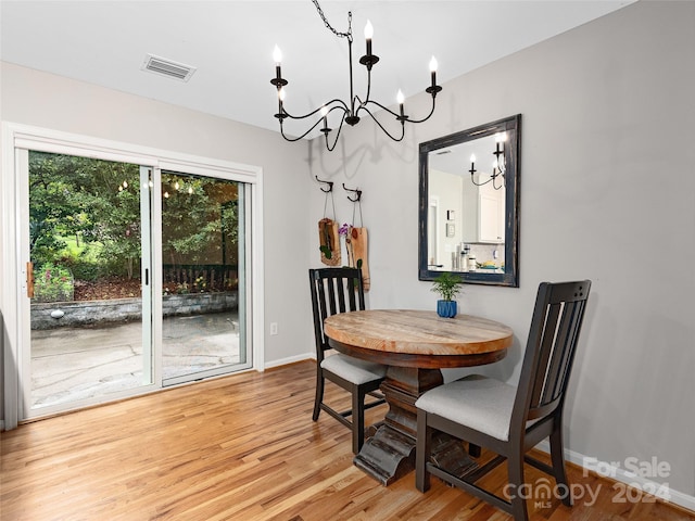 dining space with a notable chandelier and light hardwood / wood-style floors