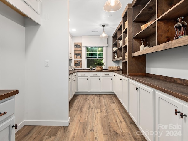 kitchen with hanging light fixtures, light hardwood / wood-style flooring, and white cabinets