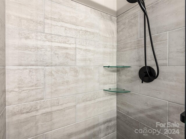 interior details featuring tiled shower