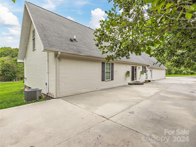 exterior space with a garage and central AC