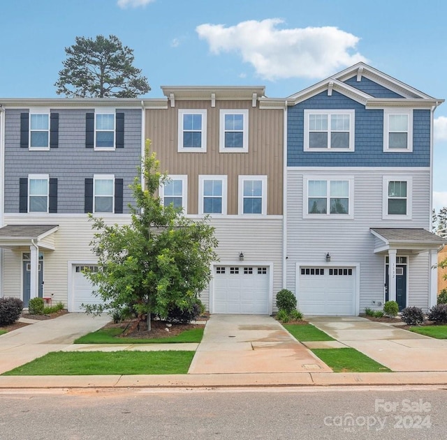 multi unit property with an attached garage and driveway