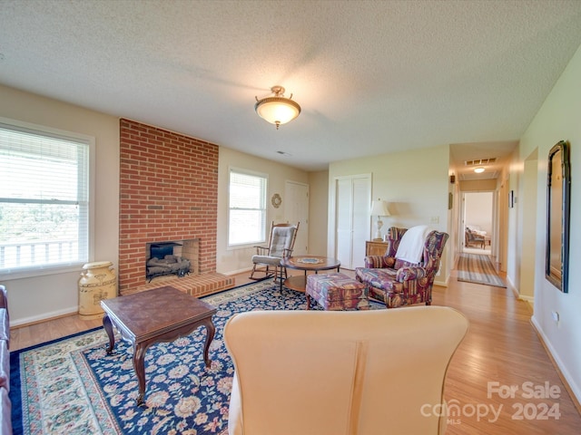 8510 Olive Branch Rd, Marshville, NC 28103 - living area featuring a textured ceiling, light wood finished floors, baseboards, and a fireplace