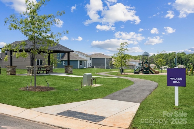 view of property's community with a gazebo, a playground, and a lawn