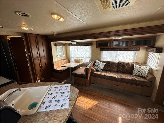 interior space featuring plenty of natural light, sink, light hardwood / wood-style flooring, and a textured ceiling