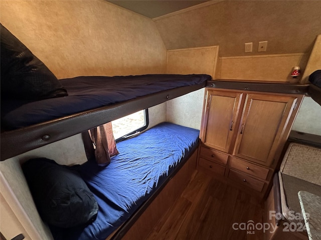 bedroom with dark wood-type flooring and vaulted ceiling