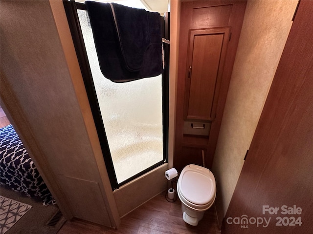 bathroom featuring hardwood / wood-style floors and toilet