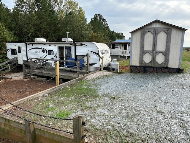 view of yard featuring a storage unit and a deck