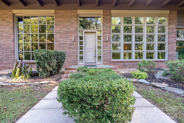 view of exterior entry featuring brick siding
