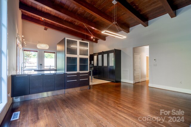 unfurnished living room with beamed ceiling, wooden ceiling, wood finished floors, and visible vents