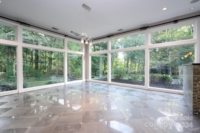 unfurnished sunroom with a chandelier and a healthy amount of sunlight