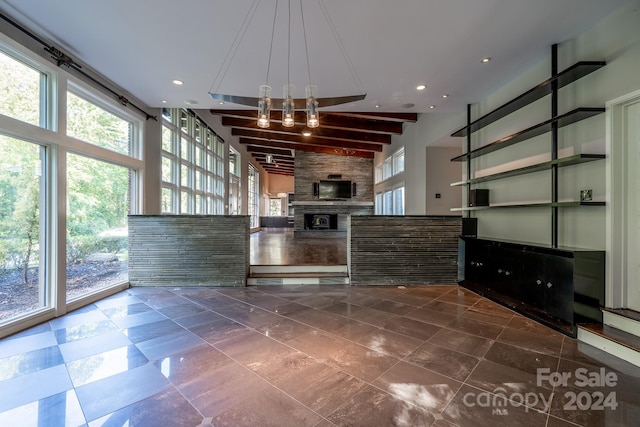 unfurnished living room featuring a high ceiling, recessed lighting, a stone fireplace, and beam ceiling