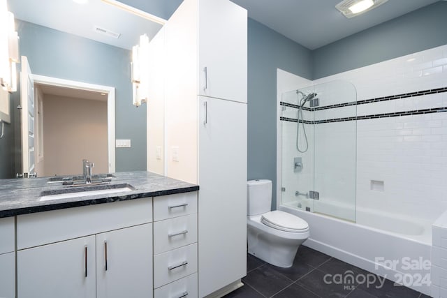 full bathroom featuring vanity, tiled shower / bath combo, toilet, and tile patterned floors