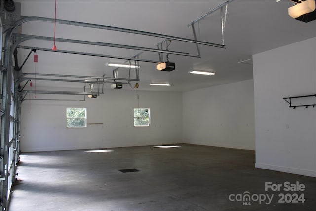 garage with baseboards and a garage door opener