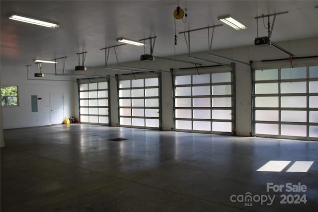 garage with a garage door opener and electric panel