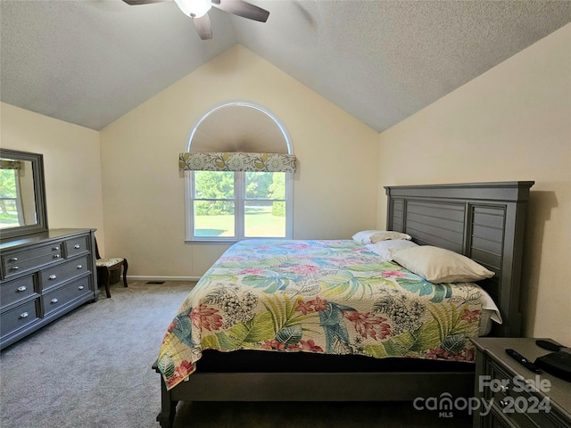 bedroom featuring a textured ceiling, lofted ceiling, light carpet, and ceiling fan