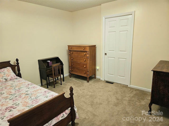 carpeted bedroom featuring a textured ceiling