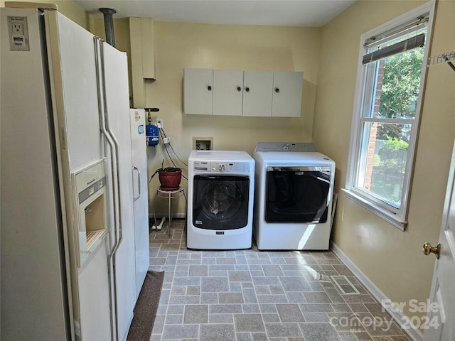 laundry area with separate washer and dryer and cabinets